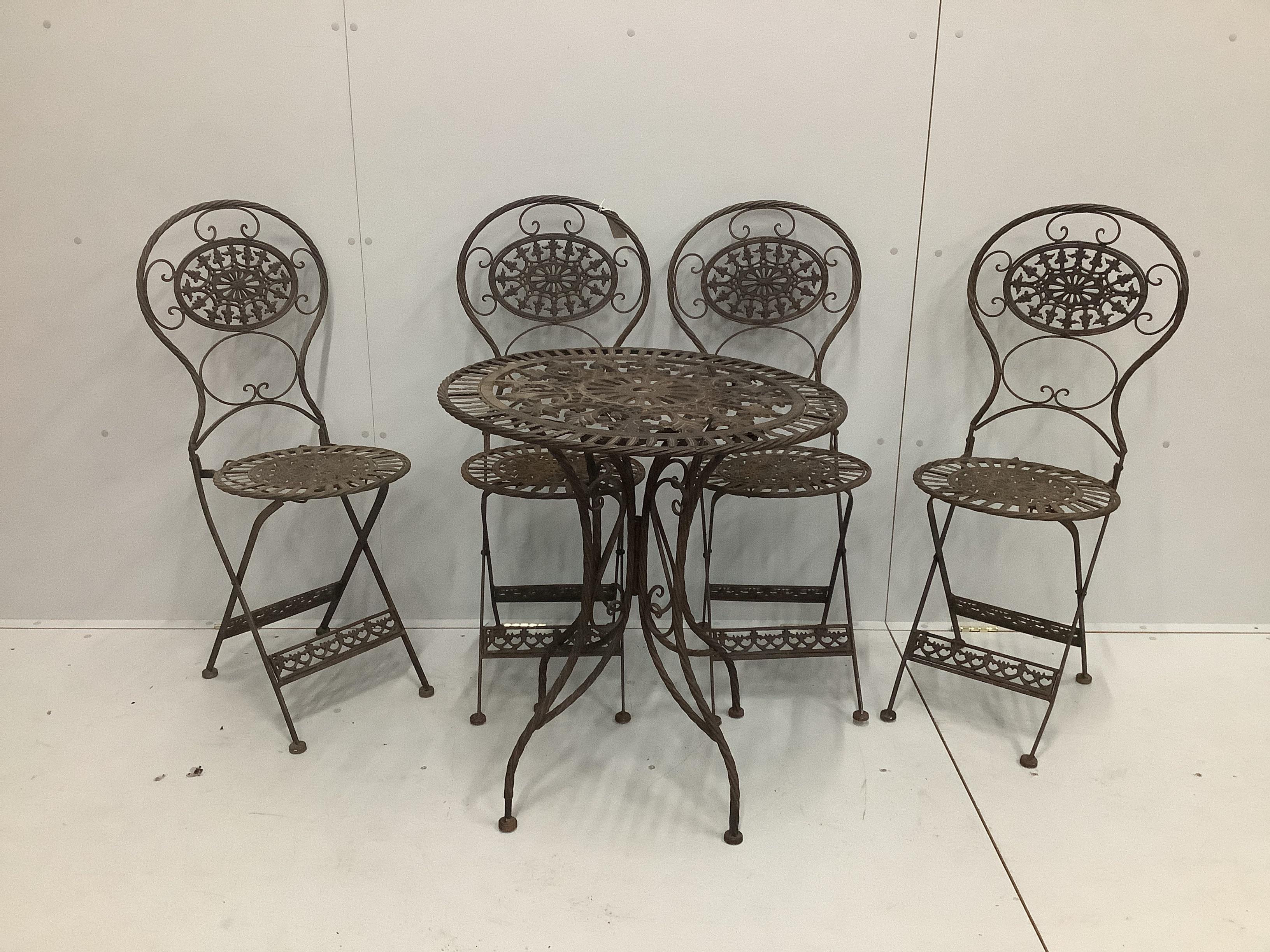 A cast iron garden table and four folding chairs